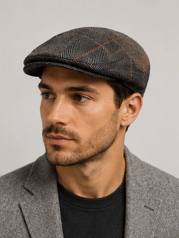 Man wearing a patterned flat cap against a plain background